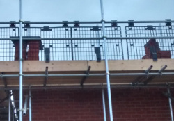 brick guards on a scaffold with piles of bricks